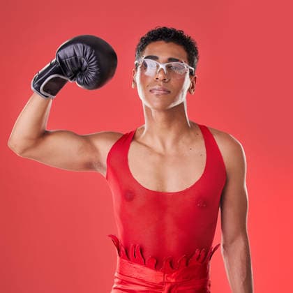 Portrait, boxing and gay man with gloves for a fight isolated on a red background in a studio. Strong, fitness and lgbt person showing muscle from self defense exercise, training and challenge. (License=RF) 19876088 ,model released, Symbolfoto  Copyright: xZoonar.com YurixArcursxpeopleimages.comx 19876088 ,model released, Symbolfoto ,property released