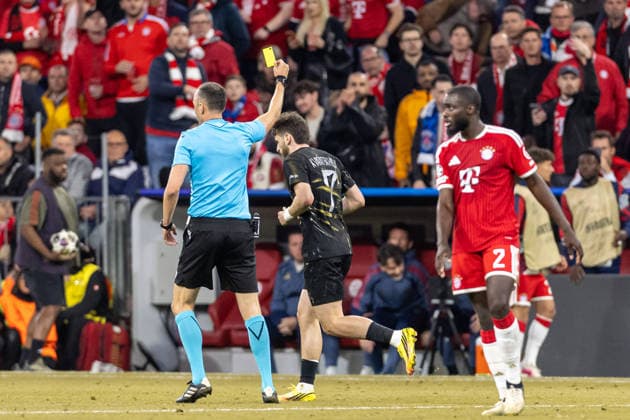 Referee Joao Pinheiro shows Kvicha Kvaratskhelia FC Paris Saint Germain the yellow card during the UEFA Champions League 2025 26 Semi Final Second Leg match between FC Bayern München and Paris Saint Germain at Football Arena Munich on May 6, 2026 in Munich, Germany