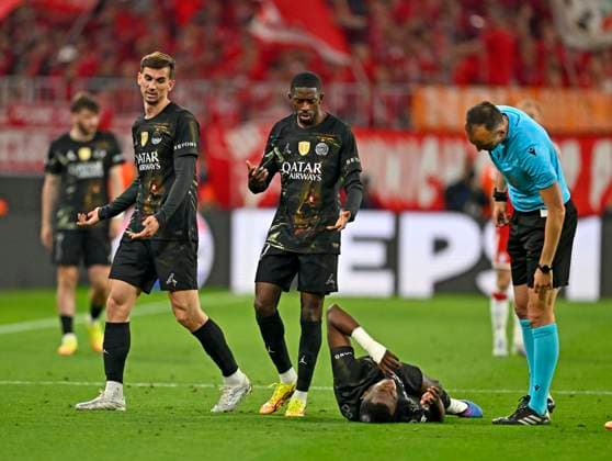 06 05 2026, Football UEFA Championsleague 2025 2026 semi-final second leg, FC Bayern Munich Paris St Germain, in the Allianz Arena Munich, Willian Pacho FC Paris Saint Germain on the ground, the referee Joao Pinheiro Portugal inquires about the condition DFL and DFB regulations prohibit any use of photographs as image sequences and or quasi video