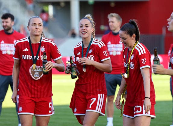 Football, Women, Google Pixel Womens Bundesliga, 25 Matchday, Season 2025 2026, FC Bayern Munich Eintracht Frankfurt, Campus The championship celebration after the match, here the FC Bayern Munich Womens team, here Magdalena Eriksson FC Bayern Munich with Giulia Gwinn FC Bayern Munich and Sarah Zadrazil FC Bayern Munich from left to right with gingerbread heart and medal as well as Radler beer