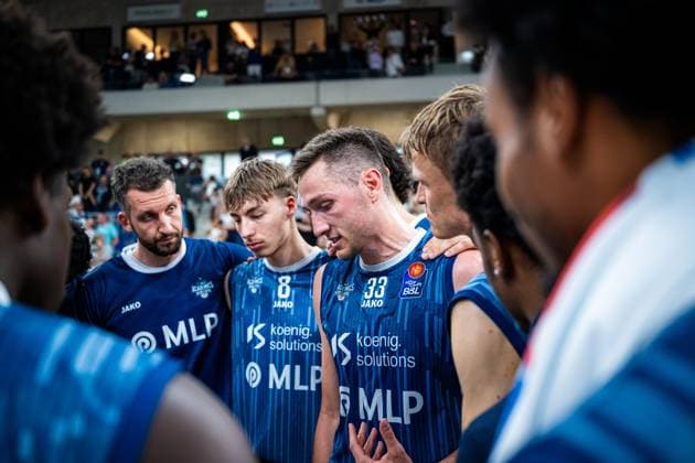 Ryan Mikesell 33 MLP Academics Heidelberg speaks intently while Dominic Vengert 8 MLP Academics Heidelberg , Niklas Würzner 2 MLP Academics Heidelberg and Paul Zipser 9 MLP Academics Heidelberg listen attentively during the BBL 2025 26 season finale in Heidelberg Intensive team meeting in Heidelberg Copyright: xMichaelxGelhardtx