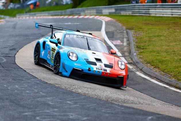 The Porsche 911 GT3 with starting number 925 from Huber Motorsport negotiates a tight bend on the Nordschleife of the Nürburgring The car Christopher Allen Hans Wehrmann Jaden Lander Jake Walker Jon Miller Jonathan Miller Robert Mau Huber Motorsport presents itself in an eye-catching light blue and orange-red color scheme with sponsors such as H R and Gran Turismo The car sits low in the bend and shows the characteristic chassis work of the Porsche GT3 on the demanding course Porsche 911 GT3 925 from Huber Motorsport on the Nordschleife Copyright: xspeedshotx