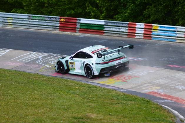 The Porsche 911 GT3 R with the starting number 24 from Lionspeed GP drives through a curve on the Nordschleife of the Nürburgring at the ADAC RAVENOL 24h Nürburgring 2026 The car in mint green design with Wempe and H R sponsoring takes the curb zone with colorful graffiti messages from the fans Laurens Vanthoor Laurin Heinrich Ricardo Feller Lionspeed GP Porsche 911 GT3 R 24 from Lionspeed GP on the Nordschleife Copyright: xspeedshotx