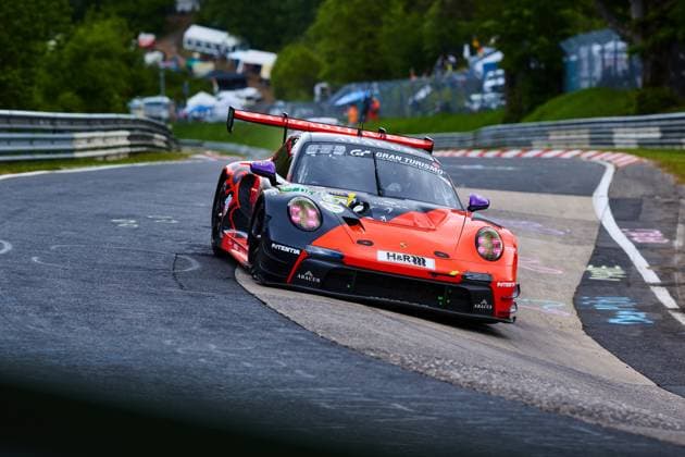 The Porsche 911 GT3 with the starting number 91 from Reiter Engineering drives through a tight curve on the Nordschleife of the Nürburgring The vehicle in bright orange and black Lukas Ertl Matthias Benndorf Maximilian Johannes Ertl Stefan Ertl Reiter Engineering carries the sponsors H R, ABACUS and Gran Turismo and shows the typical guard rails and curbs of the famous race track in the Eifel Porsche 911 GT3 91 from Reiter Engineering in the Nordschleife curve Copyright: xspeedshotx