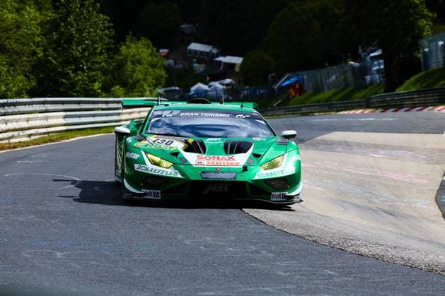 The Lamborghini Huracán GT3 with starting number 130 of the Red Bull Team ABT Marco Mapelli Nicholas Yelloly Nicky Catsburg Red Bull Team ABT drives through a curve on the Nordschleife of the Nürburgring The vehicle, which is painted in bright green, bears the sponsors Schaeffler, SONAX Müller and Gran Turismo on the bodywork The typical red and white curbs and the wooded track profile of the Nordschleife can be seen in the background Lamborghini Huracán GT3 130 of Red Bull Team ABT on the Nordschleife Copyright: xspeedshotx