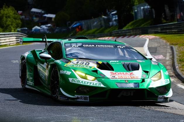 The green Lamborghini Huracán GT3 with the starting number 130 of the Red Bull Team ABT drives through a curve on the Nordschleife of the Nürburgring with the headlights switched on The car Marco Mapelli Nicholas Yelloly Nicky Catsburg Red Bull Team ABT carries the sponsors Schaeffler, SONAX Müller and H R and is equipped with Michelin tires In the background you can see the characteristic track boundaries and the green surroundings of the Eifel Lamborghini Huracán GT3 130 of Red Bull Team ABT on the Nordschleife Copyright: xspeedshotx