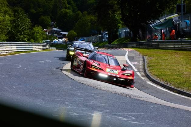 The red car with the starting number 66 from Reiter Engineering drives through a tight corner on the Nordschleife at the Nürburgring With headlights on and H R sponsoring, Arne Hoffmeister Julien Apotheloz Laurents Hörr Marcel Marchewicz Miklas Born Reiter Engineering takes the corner tightly, while another GT car follows in the background Track marshals in orange safety vests can be seen at the edge of the track Reiter Engineering 66 in the corner on the Nordschleife Copyright: xspeedshotx