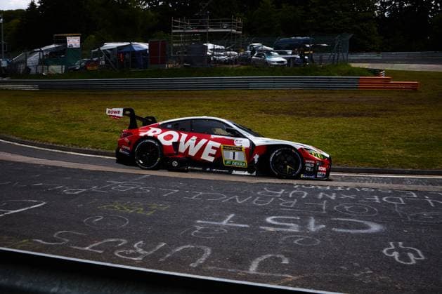The BMW M4 GT3 with starting number 1 from ROWE RACING drives through a bend on the Nürburgring The car wears the striking red and white ROWE design with RAVENOL and DEKRA sponsorship and features BMW M Motorsport branding In the foreground, catch greetings painted on the asphalt can be seen, In the background, catch fences and barriers on the race track Augusto Farfus Jordan Pepper Kelvin van der Linde Raffaele Marciello ROWE RACING BMW M4 GT3 1 from ROWE RACING at the Nürburgring Copyright: xspeedshotx