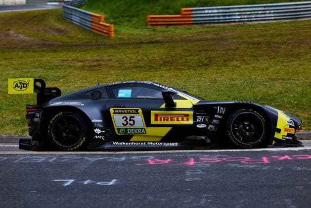 The Aston Martin AMR GT3 with starting number 35 from Walkenhorst Motorsport drives through a corner on the Nordschleife at the ADAC RAVENOL 24h Nürburgring The black and yellow car Dennis Fetzer Felipe Fernandez Laser Mateo Villagoméz Stefan Aust Walkenhorst Motorsport carries the sponsors Pirelli, RAVENOL and DEKRA prominently on the flank The characteristic crash barriers and the green grass of the Eifel can be seen in the background Walkenhorst Motorsport 35 on the Nordschleife at the 24h Nürburgring Copyright: xspeedshotx