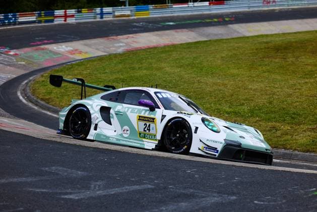 The Porsche 911 GT3 R with the starting number 24 drives through a curve on the Nordschleife of the Nürburgring The vehicle 24 TSV Schleißheim presents itself in a striking mint green and white color scheme with the sponsor PATENTIA and RAVENOL number plate Michelin tires and the DEKRA logo are clearly visible In the background, the characteristic colorful chalk drawings of the fans on the curb are visible Porsche 911 GT3 R 24 by Manthey on the Nordschleife Copyright: xspeedshotx