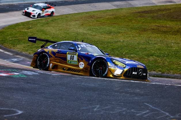 The Mercedes AMG GT3 with starting number 80 of the Mercedes AMG Team RAVENOL team drives through a tight bend at the Nürburgring The car Fabian Schiller Luca Stolz Maro Engel Maxime Martin Mercedes AMG Team RAVENOL wears the characteristic blue and gold color scheme with the sponsors RAVENOL, H R and DEKRA In the background, another car can be seen on the track Mercedes AMG GT3 80 by RAVENOL in the bend at the Nürburgring Copyright: xspeedshotx