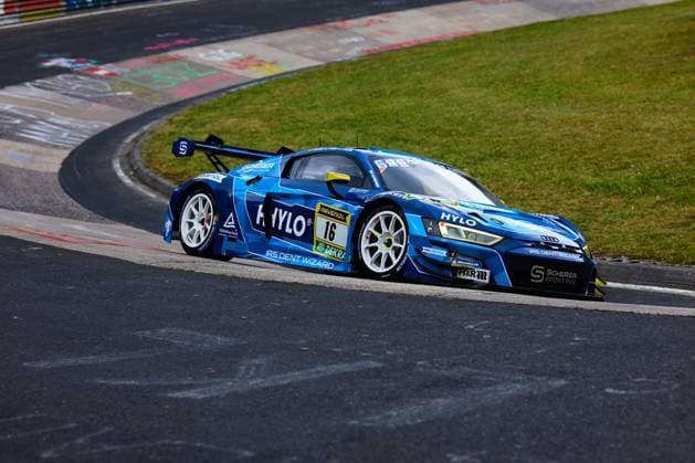 The Audi R8 LMS GT3 with starting number 16 from Scherer Sport PHX takes a corner on the Nürburgring The bright blue car Alexander Sims Ben Green Christopher Haase Scherer Sport PHX is sponsored by HYLO, RAVENOL and IRS Dent Wizard and is fitted with Michelin tires TÜV Rheinland and Scherer Sportarx are also represented as partners on the bodywork Audi R8 LMS GT3 16 from Scherer Sport PHX on the Nordschleife Copyright: xspeedshotx