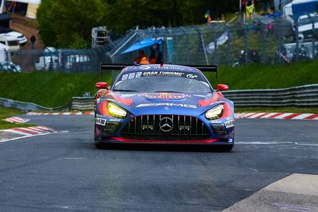 The Mercedes AMG GT3 with the starting number 3 of Mercedes AMG Team Verstappen Racing drives through a bend on the Nordschleife of the Nürburgring The blue and red car bears the sponsors Red Bull, The blue and red car bears the sponsors Red Bull, Viaplay and Gran Turismo prominently on the bodywork and is on the road with its headlights switched on Daniel Juncadella Jules Gounon Lucas Auer Max Verstappen Mercedes AMG Team Verstappen Racing is seen from the front with the characteristic Mercedes star in the radiator grille Mercedes AMG GT3 3 from Mercedes AMG Team Verstappen Racing on the Nordschleife Copyright: xspeedshotx