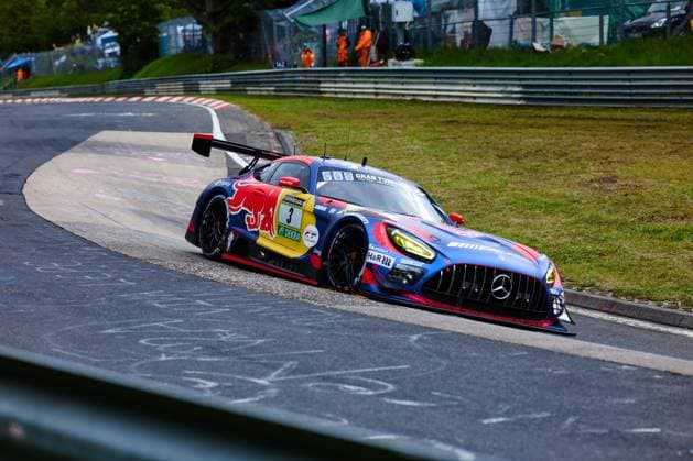 The Mercedes AMG GT3 with starting number 3 of the Mercedes AMG Team Verstappen Racing drives through a tight right-hand bend at the Nürburgring The car Daniel Juncadella Jules Gounon Lucas Auer Max Verstappen Mercedes AMG Team Verstappen Racing wears a striking Red Bull livery in blue, red and yellow with RAVENOL and DEKRA sponsorship In the background, track marshals in orange clothing and the characteristic crash barriers of the Nordschleife can be seen Mercedes AMG GT3 3 from Verstappen Racing in the bend at the Nürburgring Copyright: xspeedshotx