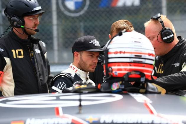 On the starting grid at the Nürburgring, the Max Kruse Racing Team prepares for the start of the race A driver in a VW GTI racing overall sits in the vehicle while team members with headsets concentrate on making final adjustments The helmet of another driver can be seen in the foreground The number 10 on a team overall can be seen on the left edge of the picture, indicating that this is Max Kruse Racing vehicle 10 Benjamin Leuchter can also be seen in the picture Max Kruse Racing VW GTI at the Nürburgring - driver change on the starting grid Copyright: xspeedshotx