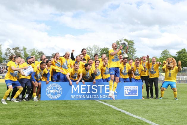 Soccer Regionalliga Nordost 1 FC Lok Leipzig 1 FC Magdeburg II 16 05 2026 Djamal Ziane 13, Lok Leipzig lifts the championship trophy in the air while the Lok team cheers and celebrates behind them Soccer, Regionalliga Nordost, Season 2025 2026, Matchday 34 1 FC Lok Leipzig vs 1 FC Magdeburg II on 16 05 2026 at Bruno Plache Stadium, Leipzig Copyright: xBEAUTIFULxSPORTS JanxKaeferx