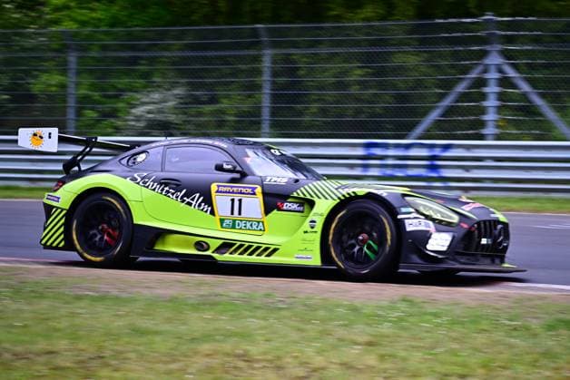 The Mercedes AMG GT3 with starting number 11 from SR Motorsport by Schnitzelalm drives through a bend on the Nürburgring The vehicle Jannes Fittje Jay Mo Härtling Kenneth Heyer Philip Ellis SR Motorsport by Schnitzelalm presents itself in an eye-catching black, yellow and green design with the Schnitzel Alm sponsorship and the logos of RAVENOL and DEKRA The photo shows the vehicle at full speed on the race track in front of green vegetation Mercedes AMG GT3 11 from SR Motorsport by Schnitzelalm on the Nürburgring Copyright: xMichaelxGelhardtx