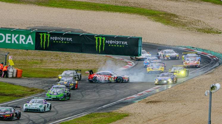 A spectacular incident occurs in a tight bend at the Nürburgring The ROWE RACING car with starting number 99 loses control and spins sideways, producing a lot of smoke, while the entire field takes the corner in a tight pack Monster Energy and DEKRA advertising banners flank the track in the background The gripping picture shows the intensity and density of the driver field at the 24-hour race at the Nürburgring Dan Harper Dries Vanthoor Max Hesse Sheldon van der Linde ROWE RACING Dramatic cornering scene with ROWE Racing 99 at the Nürburgring 24 Hours Copyright: xMichaelxSchäferx