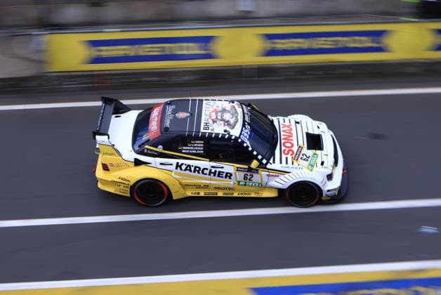 The car Luca Ludwig Markus Winkelhock Sebastian Asch HWA Engineering Speed with the starting number 62 from HWA Engineering Speed drives through the pit lane at the Nürburgring The Mercedes AMG GT3 in the striking white and yellow Kärcher design is adorned with sponsors such as SONAX, RAVENOL, Falken, DEKRA and bluechem Group The drivers names Asch, Ludwig, Winkelhock and Adelson are visible on the car door Mercedes AMG GT3 62 from HWA Engineering Speed in the pit lane Copyright: xspeedshotx