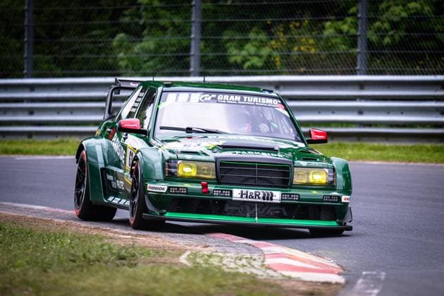 The Mercedes Benz 190E Evo from HWA Engineering Speed Adam Adelson James Green Lance David Arnold Renger Van der Zande HWA Engineering Speed takes a corner on the Nordschleife of the Nürburgring The dark green vehicle with striking yellow headlights bears the starting number 63 and is adorned with sponsors such as Parkside, H R, Hankook and Gran Turismo The vehicle features an impressive wide-track body with a large rear wing and low-tuned suspension Mercedes 190E Evo 63 from HWA Engineering Speed on the Nordschleife Copyright: xMichaelxGelhardtx