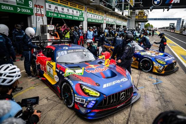 The Mercedes AMG GT3 Daniel Juncadella Jules Gounon Lucas Auer Max Verstappen Mercedes AMG Team Verstappen Racing from Mercedes AMG Team Verstappen Racing is in the pit lane of the Nürburgring for a pit stop The car wears the distinctive Red Bull livery in blue, red and gold with prominent sponsors such as Red Bull, Viaplay, Gran Turismo, RAVENOL, Falken and AMG The mechanics in blue team overalls work intently on the car, while a second vehicle - the blue and gold Falken Motorsports Mercedes AMG GT3 44 - is also being serviced in the background Numerous photographers and team members line the busy pit lane, while sponsor banners from DEKRA, ADAC, RAVENOL and Hyundai can be seen in the background Mercedes AMG GT3 3 from Verstappen Racing at the pit stop at the Nürburgring Copyright: xMichaelxGelhardtx