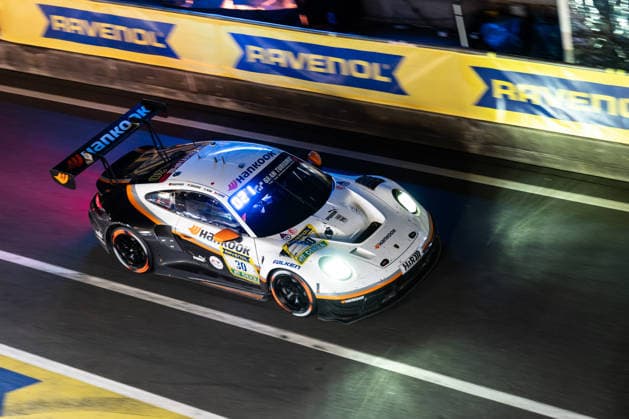 The Porsche 911 GT3 R 992 Evo26 with starting number 30 from the Hankook Competition team with drivers Jongkyum Kim, Roelof Bruins, Steven Cho and Marco Seefried drives at night in the pit lane on the Nürburgring Grand Prix circuit during the 24-hour race Nürburg Rhineland-Palatinate Germany