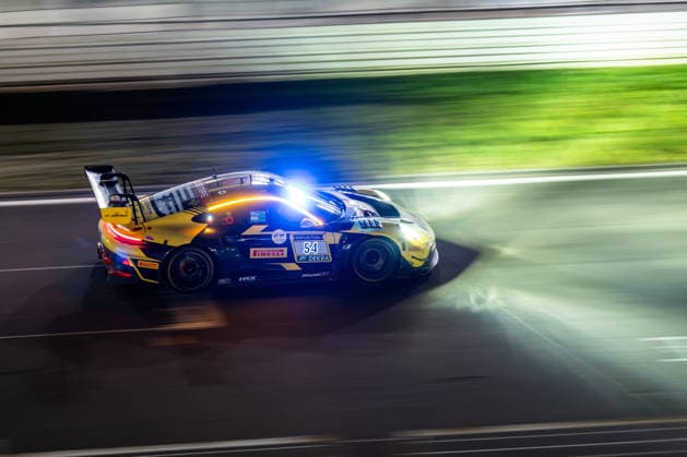 The Porsche 911 GT3 R 992 Evo26 with starting number 54 from the Dinamic GT team with drivers Bastian Buß, Michael Klitgaard Christensen, Joel Sturm and Loek Hartog drives at night on the Nürburgring Grand Prix circuit in Rhineland-Palatinate Germany during the 24-hour race.