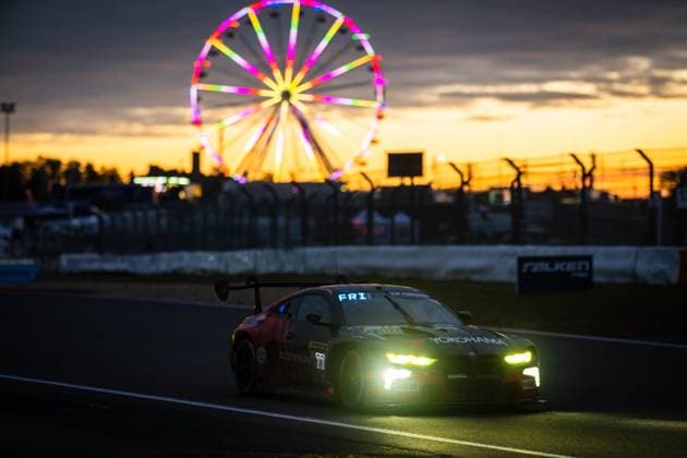 The BMW M4 GT3 Charles Weerts Marco Wittmann Philipp Eng Robin Frijns Schubert Motorsport from Schubert Motorsport drives around the Nürburgring race track as dusk falls The switched-on headlights shine brightly in the dusk, while a colorful, illuminated Ferris wheel adorns the golden sunset sky in the background, Sponsors such as Yokohama and ADVAN are clearly recognizable on the dark vehicle bodywork The Falken advertising banner on the track boundary underlines the atmosphere of the 24-hour race BMW M4 GT3 77 by Schubert Motorsport in the sunset at the Nürburgring Copyright: xMichaelxGelhardtx