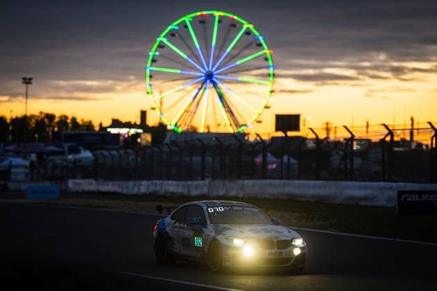The BMW M240i Racing Aldrin Opran Axel Soyez Grégoire Boutonnet Lars Harbeck Adrenalin Motorsport Team Mainhattan Wheels by Adrenalin Motorsport Team Mainhattan Wheels drives at dusk on the Nürburgring Grand Prix circuit The switched-on headlights illuminate the track, while in the background an illuminated Ferris wheel shines against an orange sunset sky The Falken banner and the pit wall can be seen in the middle ground BMW 652 from Adrenalin Motorsport at sunset at the Nürburgring Copyright: xMichaelxGelhardtx