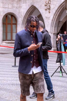 17 05 2026, Football Bundesliga 2025 2026, FC Bayern Munich championship celebration on the town hall balcony in Munich The team arrives at the town hall in traditional costume Michael Olise FC Bayern Munich on cell phone