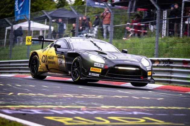 The Aston Martin GT3 Christian Krognes Mattia Drudi Nicki Thiim Felipe Fernandez Laser natural elements by Walkenhorst Motorsport from natural elements by Walkenhorst Motorsport drives dynamically through a curve on the Nordschleife of the Nürburgring The vehicle in characteristic black and yellow design with the sponsors RAVENOL, Pirelli and H R is slightly raised over the curbs In the background, numerous spectators watch the race behind the protective barrier Aston Martin 34 from natural elements by Walkenhorst Motorsport on the Nordschleife Copyright: xMichaelxGelhardtx