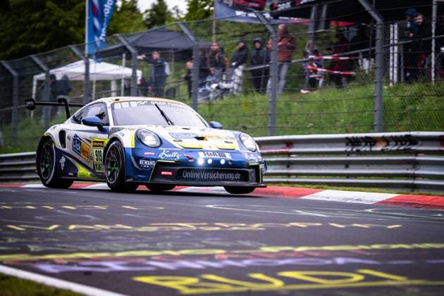 The Porsche 911 GT3 from Clickversicherung de TEAM takes Kersten Jodexnis Peter Scharmach Richard Jodexnis Richard Sven Jodexnis Robin Chrzanowski Clickversicherung de TEAM a corner on the Nordschleife of the Nürburgring The blue and white car bears sponsors such as RAVENOL, Motul, H R and OnlineVersicherung de Spectators can be seen in the background behind the safety fence Porsche 911 GT3 919 from Clickversicherung de TEAM on the Nordschleife Copyright: xMichaelxGelhardtx