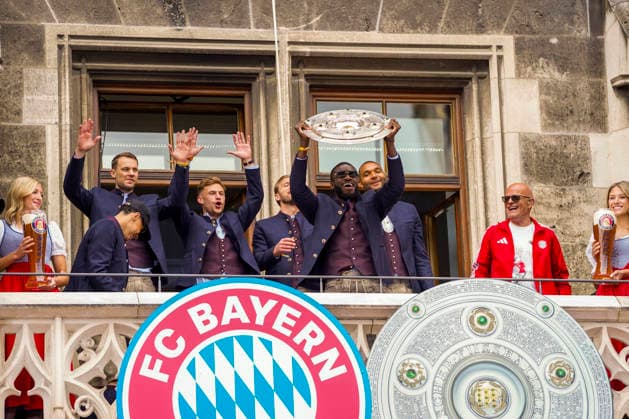 17 05 2026, Soccer Bundesliga 2025 2026, FC Bayern Munich championship celebration on the balcony of the town hall in Munich from left Jamal Musiala Bayern Munich , goalkeeper Manuel Neuer FC Bayern Munich , Joshua Kimmich FC Bayern Munich , Harry Kane FC Bayern Munich , Dayot Upamecano FC Bayern Munich , Jonathan Tah FC Bayern Munich , with the championship trophy