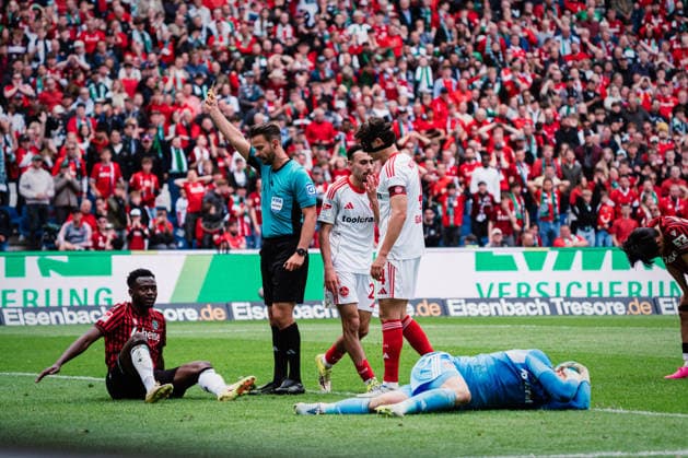 2 Bundesliga Hannover 96 vs 1 FC Nürnberg, 17 05 2026 Jan Reichert 1 FC Nürnberg, 1 lies on the ground, Mustapha Bundu Hannover 96, 7 gets the yellow card from Daniel Schlager Referee Football, 2 Bundesliga, Matchday 34 Hannover 96 vs 1 FC Nürnberg on 17 05 2026 at Heinz von Heiden Arena, Hannover DFL REGULATIONS PROHIBIT ANY USE OF PHOTOGRAPHS AS IMAGE SEQUENCES AND OR QUASI VIDEO Copyright: xBEAUTIFULxSPORTS Tonhäuserx