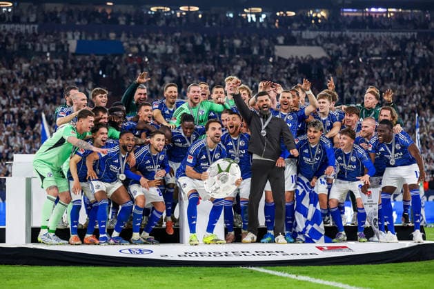 17 05 2026, Football, FC Schalke 04 Eintracht Braunschweig, Matchday 34, Bundesliga 2, Veltins Arena Gelsenkirchen, Season 2025 2026 Schalke 04 is champion of the 2 Bundesliga The team wins the championship and stands cheering on the pitch Joy and emotions after the victory Handover ceremony Kenan Karaman Schalke04 19 with the championship trophy in his hand next to head coach Miron Muslic Schalke04 on the podium DFB regulations prohibit any use of photographs as image sequences and or quasi video North Rhine-Westphalia Germany
