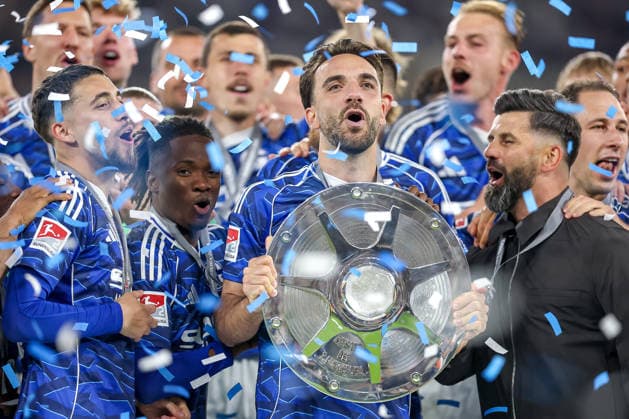17 05 2026, Football, FC Schalke 04 Eintracht Braunschweig, Matchday 34, Bundesliga 2, Veltins Arena Gelsenkirchen, Season 2025 2026 Schalke 04 is champion of the 2 Bundesliga The team wins the championship and stands cheering on the pitch Joy and emotions after the victory Handover ceremony Kenan Karaman Schalke04 19 with the championship trophy in his hand next to head coach Miron Muslic Schalke04 on the podium DFB regulations prohibit any use of photographs as image sequences and or quasi video North Rhine-Westphalia Germany