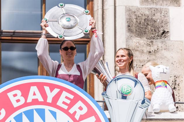 MUNICH, GERMANY - MAY 18: Glodis Perla Viggosdottir (FC Bayern Muenchen, 4), Sarah Zadrazil (FC Bayern Muenchen, 25) holding up the Google Pixel Frauen Bundesliga trophy, Klara Buehl (Bühl, Buhl, FC Bayern Muenchen, 17) holding the DFB Pokal during the Meisterfeier of FC Bayern Muenchen women at Marienplatz on May 18, 2026 in Munich, Germany. Bavaria Germany Copyright: xSteffiexWunderlx