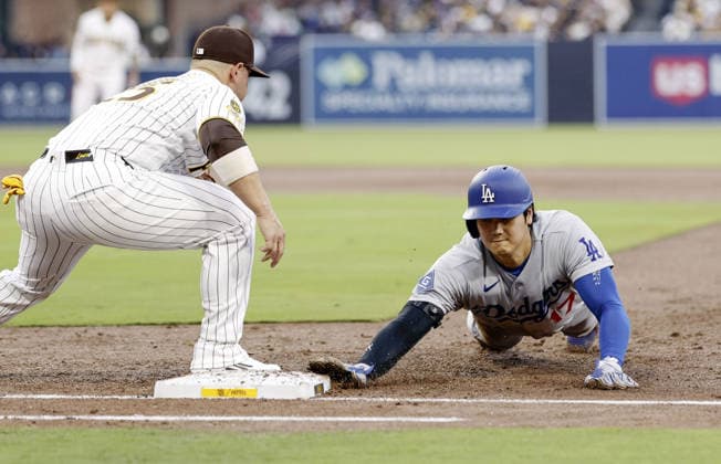 Baseball: Dodgers vs. Padres Los Angeles Dodgers designated hitter Shohei Ohtani (R) dives back to first base on a pick-off throw from San Diego Padres pitcher Griffin Canning during the third inning of a baseball game at Petco Park in San Diego, California, on May 19, 2026.  A14AA0005586798P