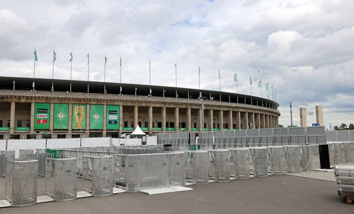 Berlin Olympic Stadium is being prepared for the DFB Cup final, barrier fences at the entrance gates, flag branding 2025 2026 20 05 2026 FC Bayern Munich vs VfB Stuttgart