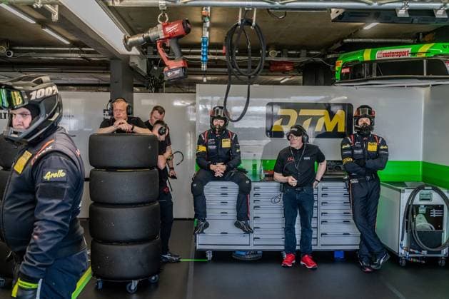 Pit scene with mechanics and team personnel in a racing garage Tires, tools and equipment are visible, several people in black team clothing and helmets prepare for a race DTM team in the garage at Circuit Park Zandvoort Copyright: xMichaelxSchäferx