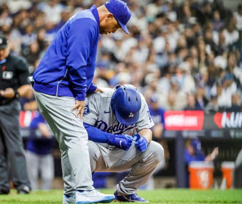 Los Angeles Dodgers manager Dave Roberts (L) checks on Los Angeles Dodgers third baseman Max Muncy (R) after Muncy was hit by a pitch thrown by Milwaukee Brewers relief pitcher Aaron Ashby in the eighth inning of the MLB, Baseball Herren, USA game between the Los Angeles Dodgers and the Milwaukee Brewers at American Family Field in Milwaukee, Wisconsin on Friday, May 22, 2026.  MIL20260522846 TANNENxMAURY