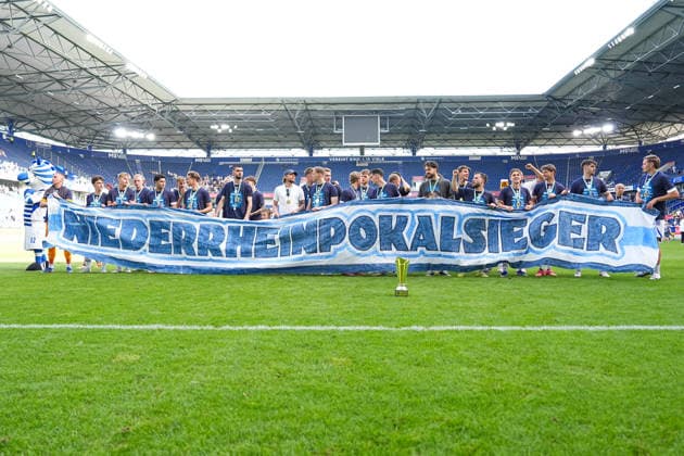23 05 2026, xydrx, men, soccer, amateur final day, Niederrheinpokal final, SC St Tönis 11 20 MSV Duisburg, 2025 2026 season, Schauinsland Reisen Arena MSV Duisburg players celebrate victory in the final with a banner in their hands Copyright: HMBxMedia YannisxDreimann