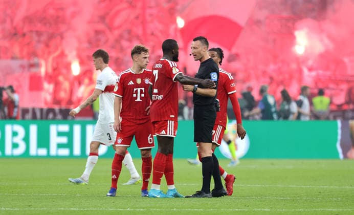 Dayot Upamecano talks to referee Sven Jablonski, behind him pyrotechnics, Bengalos, fireworks in the Stuttgart fan block Sport Football Football Final DFB Cup 2026 Season 2025 2026 23 05 2026 FC Bayern Munich FCB vs VfB Stuttgart