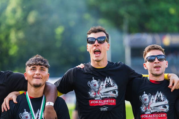 Samuele Carella Viktoria Köln, 38 , Arne Schulz Viktoria Köln, 27 , Marco Pledl Viktoria Köln, 17 with cup winner shirts and derby winner glasses on singing Fortuna Köln vs FC Viktoria Köln, Football, Landespokal Mittelrhein 2025 26, Final, Season 2025 26, 23 05 2026, Fortuna Köln vs FC Viktoria Köln, Football, Landespokal Mittelrhein, Final, Season 2025 26, 23 05 2026 Köln Copyright: xEibner-Pressefoto LukasxBaldygax EP_LBA