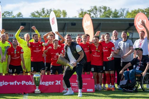 Pascal Reinhardt coach SG Sonnenhof Großaspach holds up the cup, in the background his team cheers, Stuttgarter Kickers vs SG Sonnenhof Großaspach, Football, WFV Cup, Final, 23 05 2026 Stuttgart Degerloch Baden Wuerttemberg Germany Copyright: xkolbert-press PhilipxZieglerx