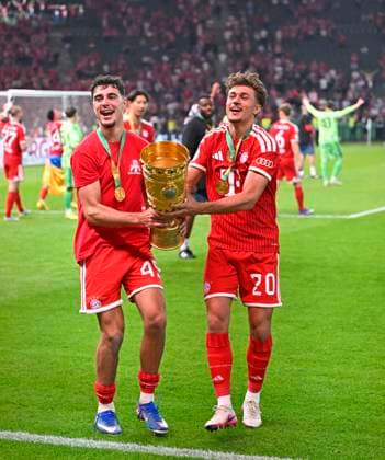 23 05 2026, Football DFB Pokal 2025 2026, Final, FC Bayern Munich VfB Stuttgart, in the Olympiastadion Berlin v l Aleksandar Pavlovic Bayern Munich and Tom Bischof Bayern Munich cheer with the cup DFL and DFB regulations prohibit any use of photographs as image sequences and or quasi video
