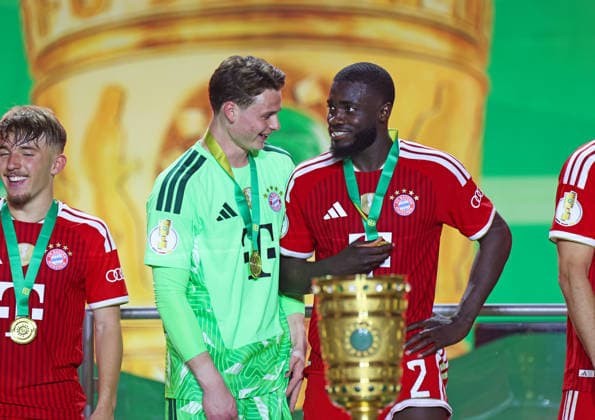 Football, Men, DFB Cup Final, Season 2025 2026, FC Bayern Munich VFB Stuttgart, Olympiastadion Berlin The FC Bayern Munich team celebrates winning the DFB Cup here after the match, in the picture Jonas Urbig FC Bayern Munich left with Dayot Upamecano FC Bayern Munich right in conversation DFB, DFL regulations prohibit any use of photographs as image sequences and or quasi video