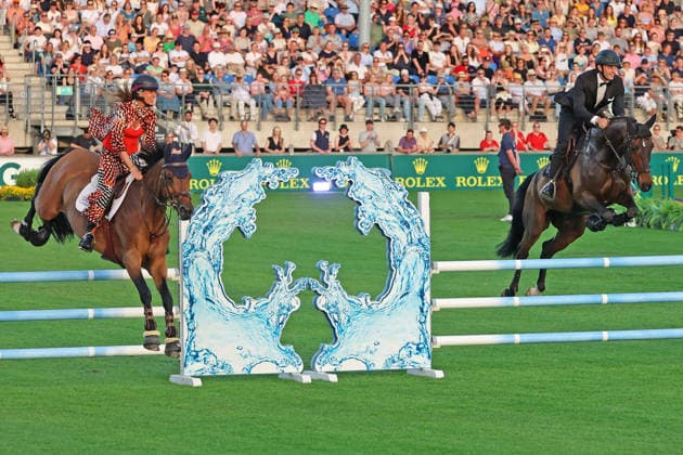 Richard Vogel and Luciana Diniz together in Bond Stunt Feeling over the obstacles, concert horse symphony, supporting program, motto of the evening James Bond, World Equestrian Festival, TSCHIO Aachen 2026, TSCHIO instead of CHIO 2026, Aachener Soers, 22 to 24 May 2026, equestrian sport, 23 05 2026, Aachener Soers Germany