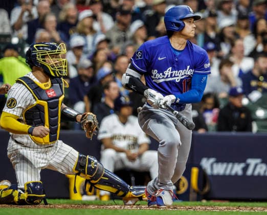 Los Angeles Dodgers designated hitter Shohei Ohtani hits a single in front of Milwaukee Brewers catcher Gary Sanchez in the seventh inning of the MLB, Baseball Herren, USA game between the Los Angeles Dodgers and the Milwaukee Brewers at American Family Field in Milwaukee, Wisconsin on Saturday, May 23, 2026.  MIL20260523828 TANNENxMAURY