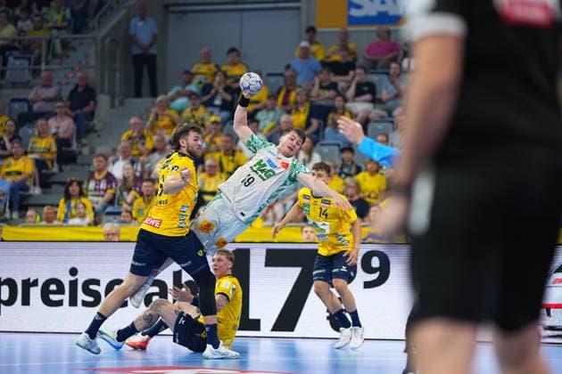 Elvar Örn Jonsson 19, SC Magdeburg in white jersey takes a shot from the back and is pressured by Steven Plucnar Jacobsen 9, Rhein Neckar Löwen Edwin Aspenbäck 78, Rhein Neckar Löwen can be seen in the background - Scene from the DAIKIN HBL match in the SAP Arena Elvar Örn Jonsson 19, SC Magdeburg taking a shot against Rhein Neckar Löwen in the SAP Arena Copyright: xspeedshotx